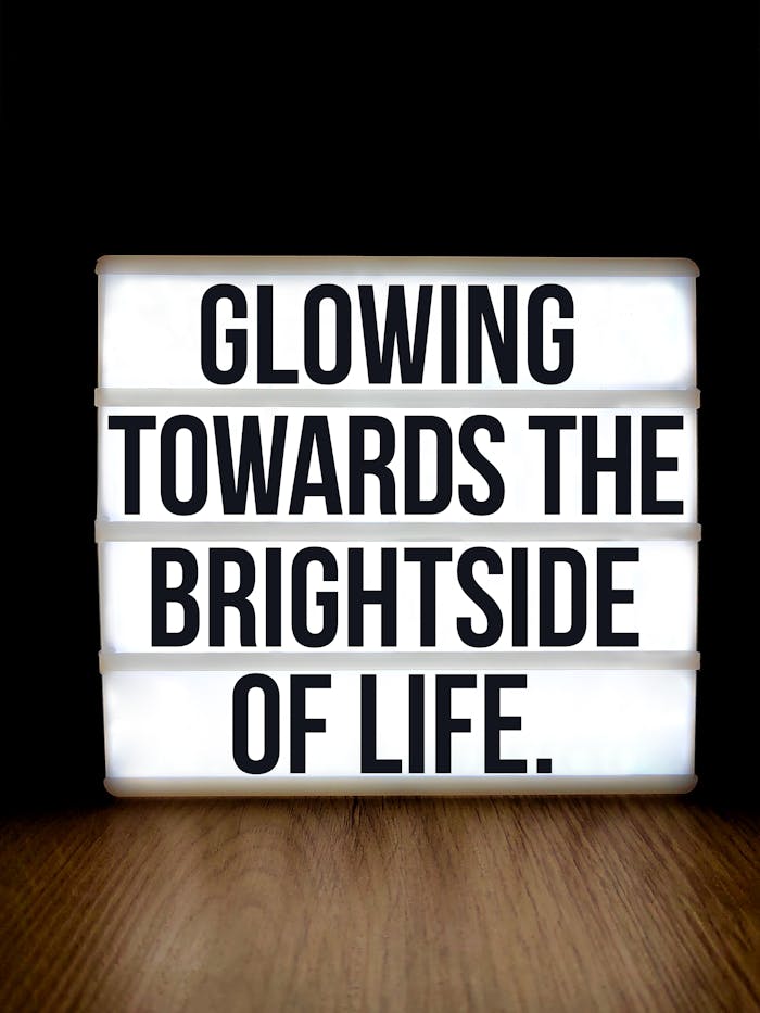 Lightbox sign displaying an inspiring quote on the bright side of life, set against a black background.